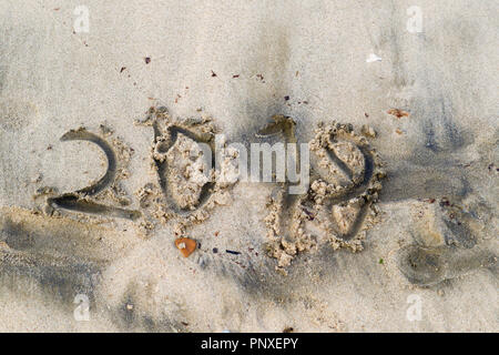 Laid et maladroit lettres 2018 sur une plage de sable, concept de l'année sortante. Texture rugueuse Banque D'Images