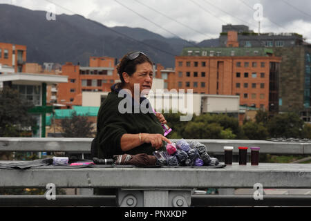 Bogota, Colombie - 17 mai 2017 : un frontalier qui utilise le système de transit rapide par bus TransMilenio Calle 127, est vu demander le prix des parasols. Banque D'Images