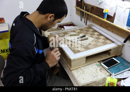 Tachkent, Ouzbékistan - 02 mai 2017 : artisan ouzbek inconnu sur son lieu de travail à l'intérieur de la madrasa. Banque D'Images