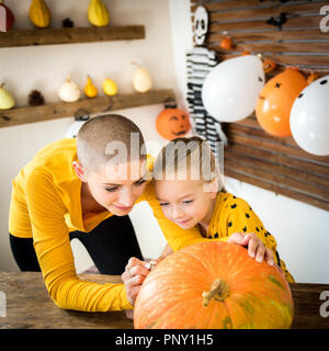 Mère et fille ; le visage anthropomorphe smiley dessin sur une grande Halloween citrouille. Décoration de la famille des citrouilles. Banque D'Images