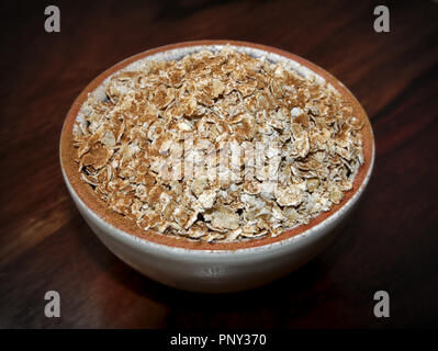 L'avoine porridge avec un saupoudrage de cannelle sur une surface de bois foncé Banque D'Images