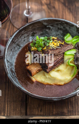 Bouts de côte de bœuf mijoté lentement avec des pommes de terre, champignons et sauce. Banque D'Images