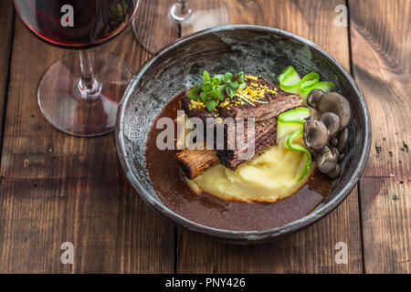 Bouts de côte de bœuf mijoté lentement avec des pommes de terre, champignons et sauce. Banque D'Images