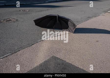 A broken umbrella réside dans la route Banque D'Images