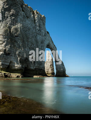 Falaises de craie d'Etretat (Normandie France) avec l'arche naturelle Porte d'aval et l'aiguille de pierre appelé L'aiguille. L'aiguille est visible à travers le Banque D'Images