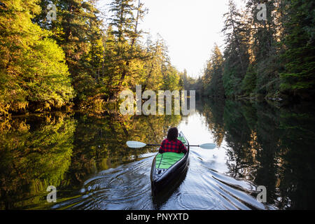 Girl kayak dans la belle rivière lors d'un matin d'été ensoleillé. Prises dans la baie San Josef, Cape Scott, Nord de l'île de Vancouver, BC, Canada. Banque D'Images