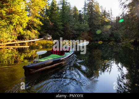 Girl kayak dans la belle rivière lors d'un matin d'été ensoleillé. Prises dans la baie San Josef, Cape Scott, Nord de l'île de Vancouver, BC, Canada. Banque D'Images