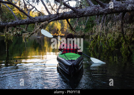 Girl kayak dans la belle rivière lors d'un matin d'été ensoleillé. Prises dans la baie San Josef, Cape Scott, Nord de l'île de Vancouver, BC, Canada. Banque D'Images