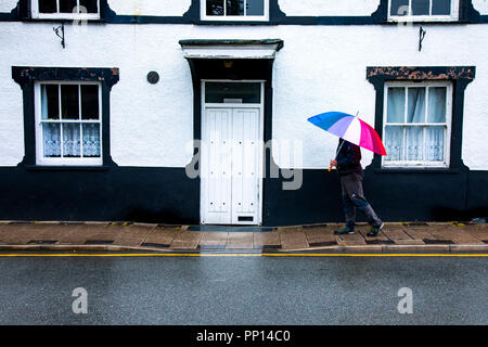 Conwy, au Royaume-Uni. Septembre 2018. Météo France : un sentiment d'automne dans l'air sur l'Équinoxe d'automne le premier jour de l'automne avec des températures plus froides, la pluie comme une personne avec un parapluie multicolore promenades passé un vieux bâtiment dans le village de Llanrwst, au nord du Pays de Galles Banque D'Images