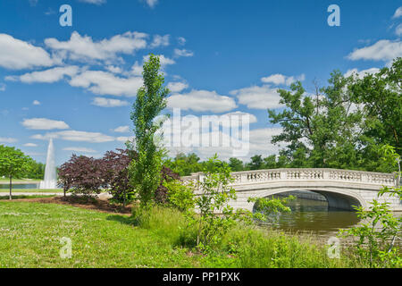 Ciel spectaculaire sur le pont à côté de feuilles pourpres redbud arbres et un peuplier à côté du Grand Bassin à Saint Louis Forest Park. Banque D'Images
