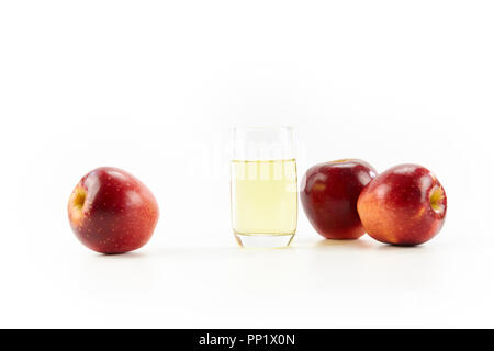 Trois pommes et un verre de jus de pomme isolé sur fond blanc. Banque D'Images