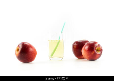 Trois pommes et un verre de jus de pomme isolé sur fond blanc. Banque D'Images