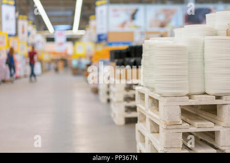 De nombreuses planches sur l'étagère du magasin blanc de la cuisson. Des étagères dans une variété de plaques blanches dans le magasin. Cuisine en porcelaine. Banque D'Images