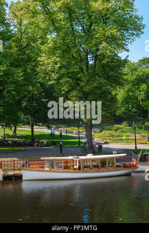 Riga parc, vue sur un après-midi d'été d'un bateau de plaisance amarrés dans le Bastion Hill Park (Bastejkalns) dans la région du canal du centre-ville de Riga, en Lettonie. Banque D'Images