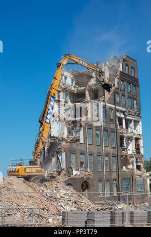 De grandes machines de démolition élevant un bâtiment haut au sol à Londres. Banque D'Images