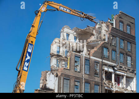 De grandes machines de démolition élevant un bâtiment haut au sol à Londres. Banque D'Images