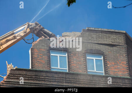 De grandes machines de démolition élevant un bâtiment haut au sol à Londres. Banque D'Images