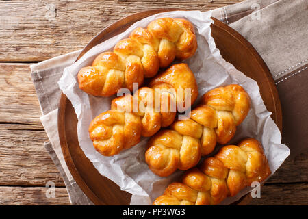 South African Koeksisters frit beignet collante est doux, collant, crisp et imbibé de sirop sur une assiette sur la table horizontale à partir de la vue de dessus. Banque D'Images