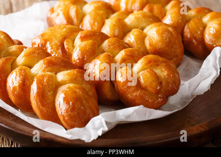 Sud-africain traditionnel beignet collant Koeksisters traiter c'est délicieusement doux et collant, croquantes et trempé dans du sirop macro sur une plaque horizontale. Banque D'Images