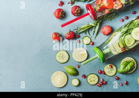 Detox eau infusée avec des fruits, des baies assaisonnés à l'aide de fines herbes et de concombre dans des bouteilles avec paille, vue du dessus Banque D'Images