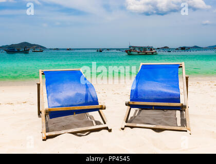 Très belle plage de sable blanc. Des chaises sur le premier plan, des bateaux de pêche sur l'arrière-plan. Paysage du Vietnam Banque D'Images