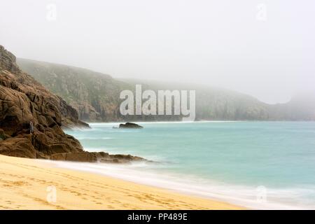 Regarder sur plage de Porthcurno sur un matin brumeux cornish,Cornwall, Angleterre, Royaume-Uni Banque D'Images