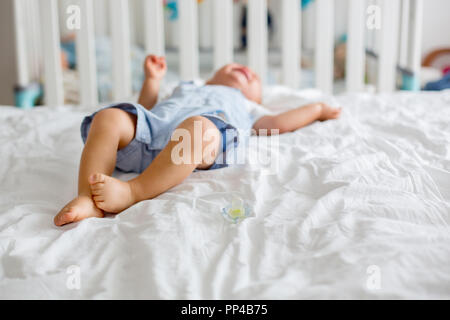 Bébé garçon enfant, jouer avec dummy, malheureux pour pleurer la sucette dans chambre enfants Banque D'Images