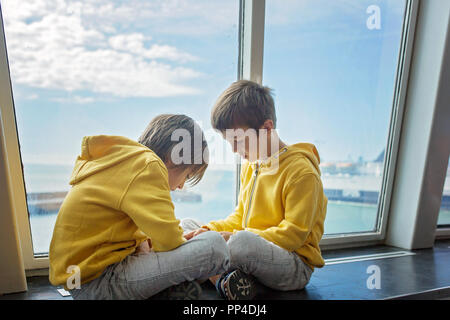 Beaux enfants, à bord du ferry, qui voyagent pour des vacances d'été Banque D'Images