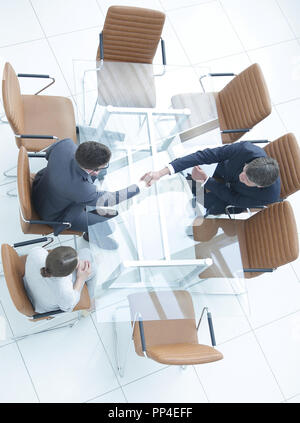 Poignée de l'autre côté de la table. Rencontre autour d'une table de conférence. Banque D'Images