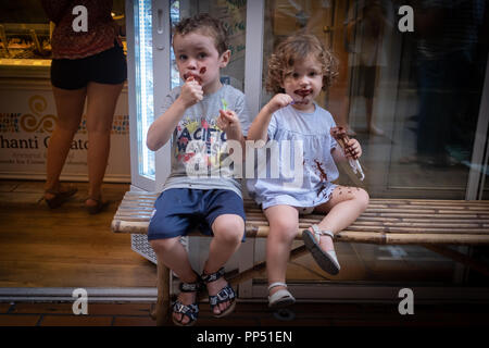 Barcelone, Espagne. 22 septembre 22, 2018 : deux enfants avec get glace chocolat sur leurs visages et vêtements tout en restant assis dans la rue : Crédit photographique à vue/Alamy Live News Banque D'Images