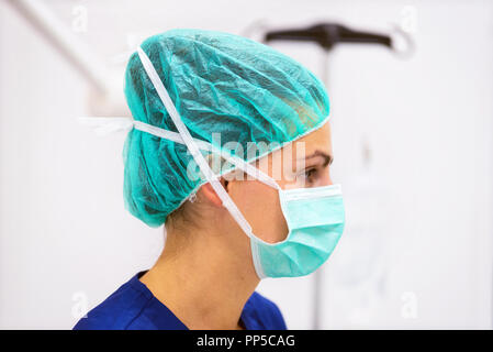 Portrait médecin avec masque de protection et hat in operating room Banque D'Images