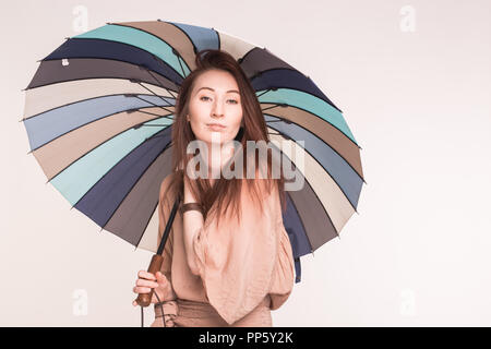 Pretty asian woman holding umbrella colorés sur fond blanc Banque D'Images