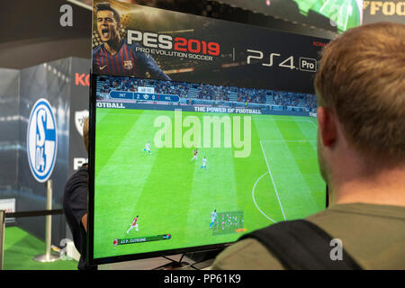 Visiteurs jouent le jeu de simulation de football PES 2019, Pro Evolution Soccer 2019 à la Gamescom, le plus grand producteur mondial d'ordinateur et les jeux vidéos juste à Cologne, en Allemagne, le 24.8.2018 Banque D'Images