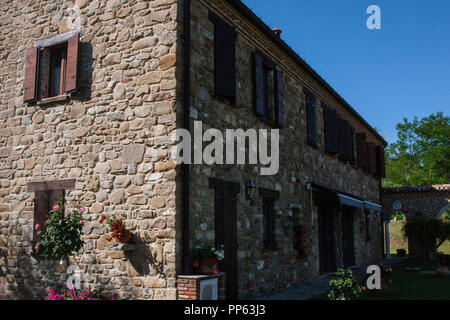 Image de fond de l'ancienne maison de ferme en pierre avec des fenêtres en bois en pleine nature sur une journée d'été. Pas de personnes. Banque D'Images