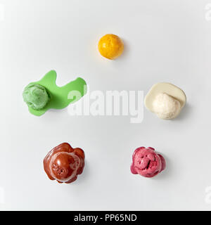 Mise à plat des glaces colorées - vanille, chocolat, berry, Mangue, Menthe. Boules de glace a fondu sur un fond blanc. Banque D'Images