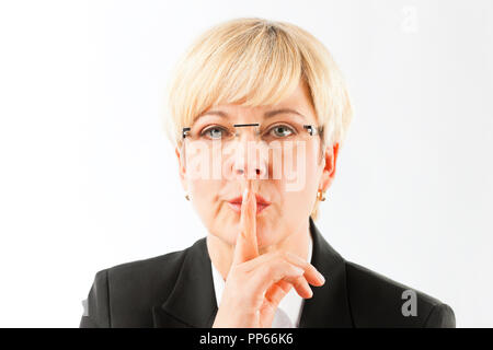 Mature businesswoman making geste silencieux Banque D'Images