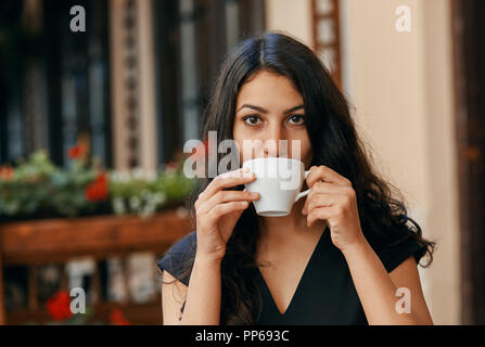 Jeune femme arabe de boire du café dans un café Banque D'Images