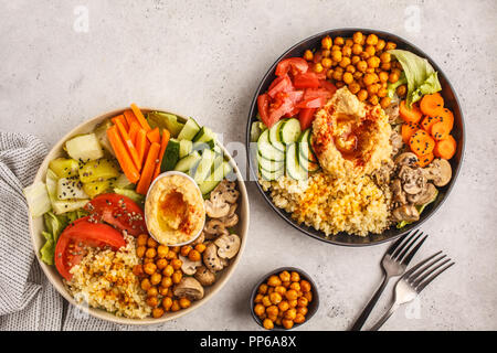 Bols de Bouddha avec des légumes, champignons, boulgour, pois chiches cuits et l'hummus. Fond blanc, vue du dessus. La nourriture végétalienne saine concept. Banque D'Images