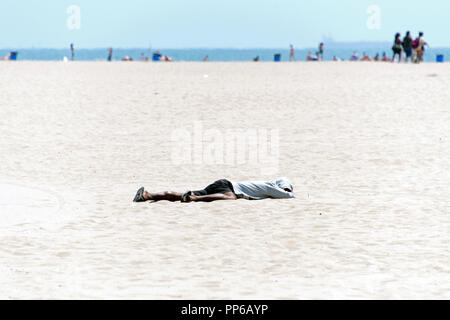 Un sans-abri guy dort sur la plage de Venice, en Californie Banque D'Images