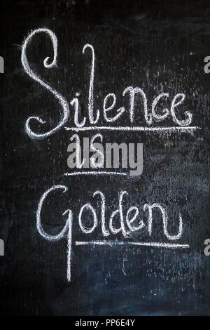 «Silence est d'Or" écrit sur un tableau noir proverbe Banque D'Images