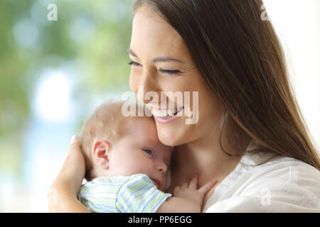 Portrait d'une mère tenant son bébé satisfait à la maison