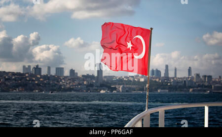 O vue de brandir le drapeau turc sur un ferry avec le paysage urbain de côté européen d'Istanbul. Banque D'Images