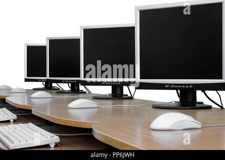 Rangée de moniteurs d'ordinateur en classe. Fond blanc, isolé. Banque D'Images