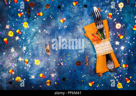 Les paramètres de table Halloween sur fond bleu foncé avec des confettis citrouille d'or, araignées et candy corns. Mise à plat de style. Maison de vacances à la mode image instagram Banque D'Images
