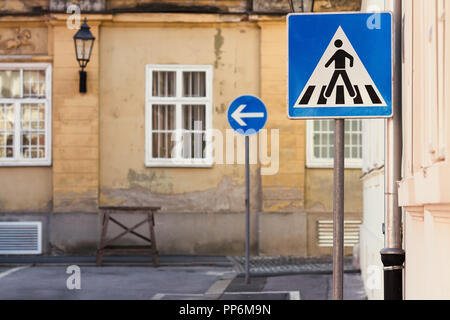 Les panneaux de signalisation bleus en face d'un vieux bâtiment en Europe Banque D'Images