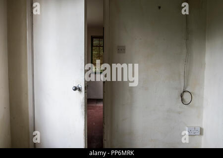 Détail du vitrail mur et ouvrir légèrement la porte sale dans la maison vide, câble électrique pendant vers le bas. Banque D'Images