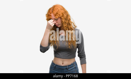 Jeune femme rousse fatigué se frottant le nez et les yeux sentant la fatigue et les céphalées. Le stress et la frustration concept. Banque D'Images