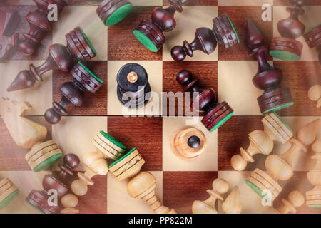 Une photo prise à la verticale d'une situation d'échecs en échec et mat avec presque tous les morceaux tombés sur l'échiquier, avec blurred motion Banque D'Images