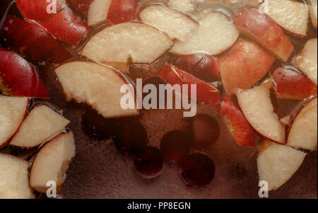 Les tranches de pomme colorée, mélange de fruits dans un pot. Cidre de pomme fruits rafraîchissante boisson Punch party. Les aliments biologiques lueur chaude Arrière-plan. Banque D'Images