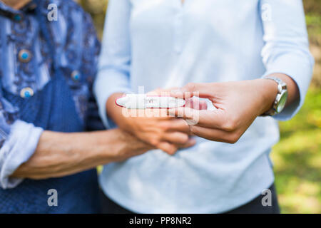 Photo Close up of young woman holding test de grossesse avec grand-mère. Arrière-petits sur le chemin Banque D'Images